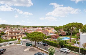 Residential homes with diverse architectural styles and lush gardens surround a swimming pool.