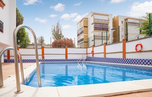 Enjoy a refreshing swim in the pool surrounded by a low wall with a checkered base.