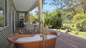 A wooden deck with a hot tub, outdoor furniture, and a view of a garden. - Saltwater Creek - immerse yourself in nature (Barringella)
