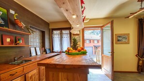 A kitchen with wooden cabinets, a wooden countertop, and a fruit bowl. - Awesome apartment in Pezzoro (Pezzoro)
