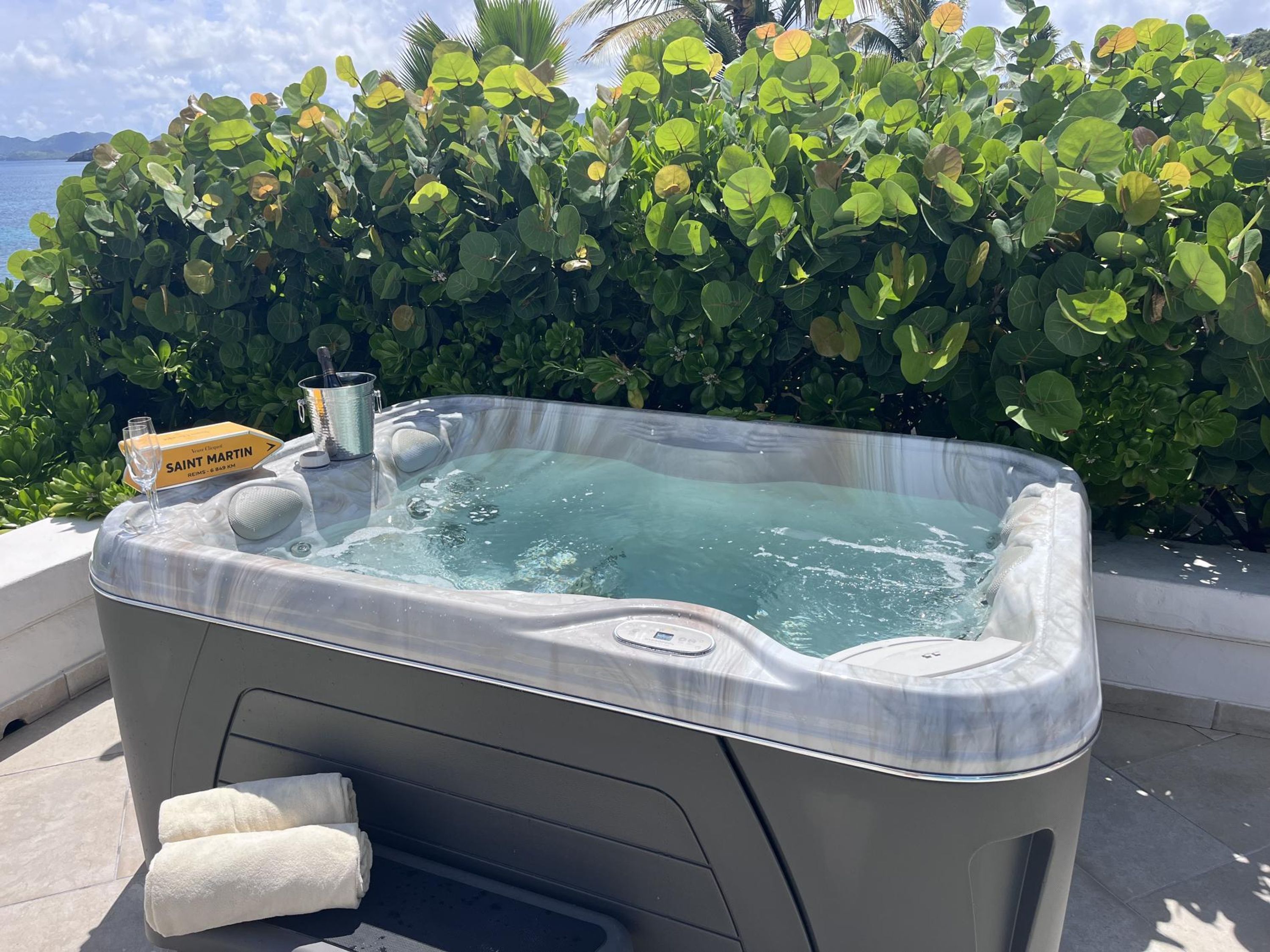 A hot tub with a glass top, a towel, and a sign indicating Saint Martin.