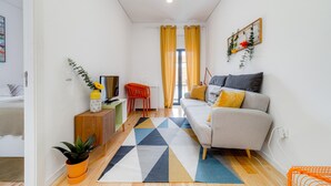 A modern living room with a sofa, a small table, a potted plant, and a colorful rug. - Nomad s Netto Subway - Sunny Balcony (Porto)