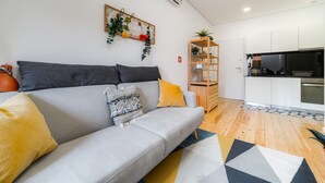 A modern living room with a grey sofa, yellow cushions, a patterned throw, and a wooden sideboard. - Nomad s Netto Subway - Sunny Balcony (Porto)