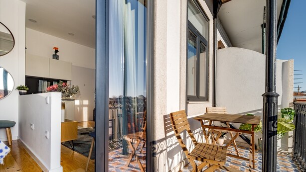 Un intérieur moderne comprenant un coin repas, une cuisine et une vue sur l’extérieur grâce à une porte vitrée.