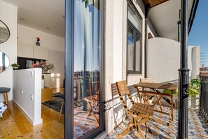 Interior moderno com área de refeições, cozinha e vista através de uma porta de vidro.