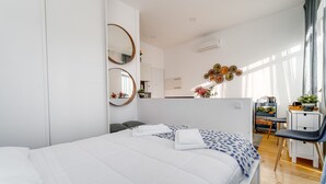 Une chambre à coucher moderne, avec un lit, des tables de chevet, un bureau et une chaise.