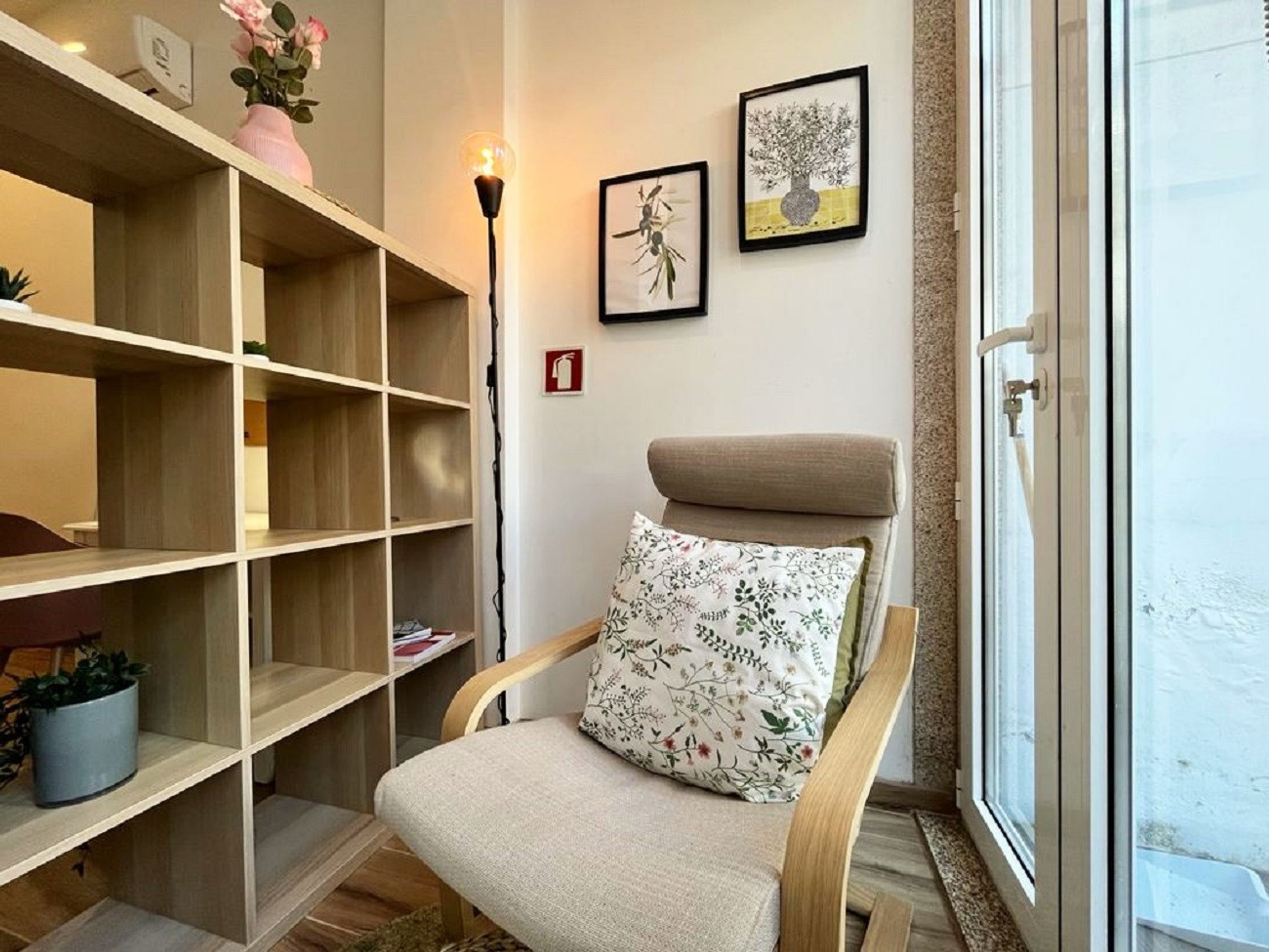 A corner room with a wooden chair, a bookshelf, and a window.