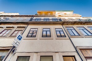 A building facade with a parking sign, multiple windows, and a balcony. - Nomad s Netto Subway - Lovely Terrace (Porto)