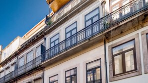 A multi-story building with balconies, a parking sign, and a car parked on the street. - Nomad s Netto Subway - Lovely Terrace (Porto)