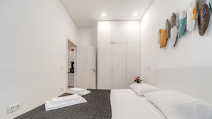 A hotel room with a bed, a wardrobe, and a wall with decorative plates. - Nomad s Netto Subway - Lovely Terrace (Porto)