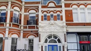 A multi-story building with classic architectural features, including arched windows and decorative moldings. - Apartment Sleeps 2 with Free Parking (London)