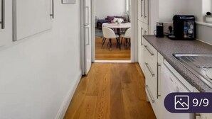 A narrow hallway leading to a dining area with a table and chairs. - Apartment Sleeps 2 with Free Parking (London)