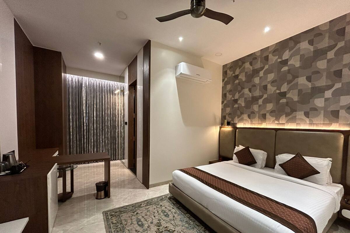 Ein modernes Hotelzimmer mit einem großen Bett, einem Schreibtisch und einem Deckenventilator.