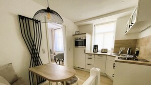 Ett kompakt kök med en matplats, en mikrovågsugn, en kaffebryggare och en brödrost.