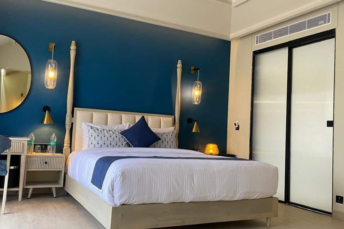 Ein Schlafzimmer mit Bett, Nachttischen, einem Sessel, einem Spiegel und einem Kleiderschrank.