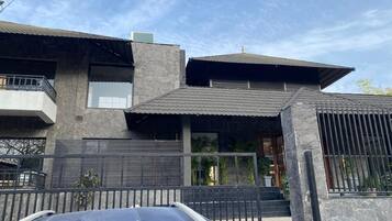 A modern two-story house with a garage, a balcony, and a gated entrance.