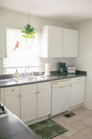 A kitchen with white cabinets, a sink, a coffee maker, and a toaster. - The Blue Jay House in North Fondren (Jackson)