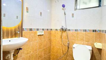 Un baño pequeño con inodoro, lavabo y ducha.