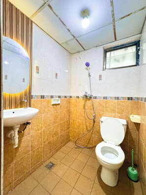 A small bathroom with a toilet, sink, and shower. - Beranda Istirahat 2BR Laguna Pluit (Jakarta)