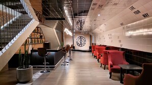 A modern interior with a bar area, red seating, a staircase, and motivational wall text. - Apartamento Moderno en Ciudad Cayalá (Ciudad de Guatemala)