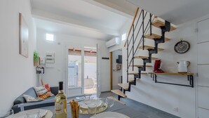 Une cuisine moderne avec un escalier, un coin repas et une vue sur l’extérieur.