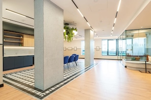 A modern office space with a reception area, blue chairs, and a patterned floor.