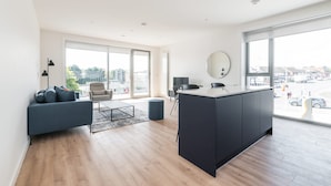A modern living room with a sofa, a dining table, and a kitchen island. - The Cornerstone Two by Dublin At Home (Dublin)