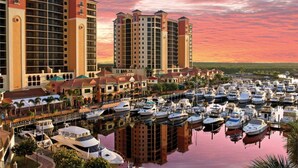 A marina with multiple boats docked, surrounded by high-rise buildings with balconies. - Fort Myers River District Condo Close to Shopping, Dining & Nightlife! Heated Pool & Free Parking! (Fort Myers)