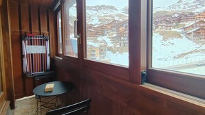 A wooden-paneled room with a view of a snowy mountain town. - Friendly duplex 6 people. 39m² 3 separate sleeping areas, EAST balcony view. (VAL THORENS)