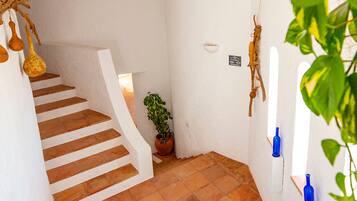 A staircase with terracotta tiles leading to a landing.