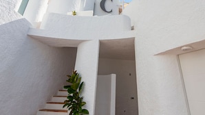 A white building with a staircase leading to a door marked with a large 'C'. - Castell Mar 1006 in Roses (Roses)