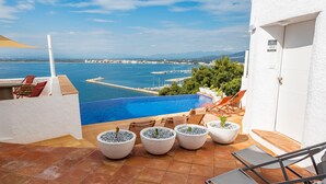 A terrace with a pool, outdoor seating, and a view of the sea. - Castell Mar 1003 in Roses (Roses)