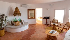 Una sala de estar con un espacio de descanso circular, un espejo grande y una planta en maceta.