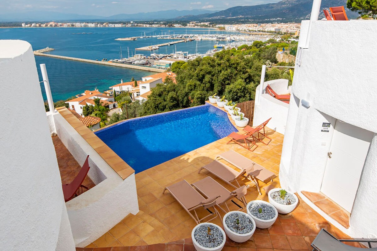 Una piscina en la azotea con vistas al mar y al paisaje urbano.