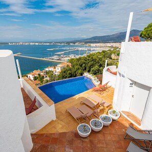Una piscina en la azotea con vistas al mar y al paisaje urbano.