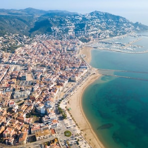 An aerial view of a coastal city with a densely packed urban area, a long sandy beach, and a clear blue sea. - Les Roques 6 in Roses (Roses)