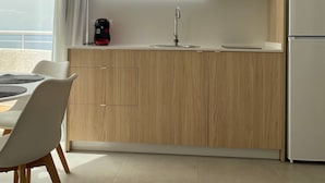 A modern kitchen with wooden cabinets, a built-in microwave, and a coffee machine.