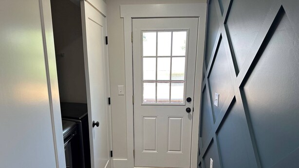 A hallway with a white door, a window, and a dark wall with geometric patterns. - NEW Bungalow - Fenced yard - 30+ day rental - View of Lookout Mountain - Chattanooga (Chattanooga)