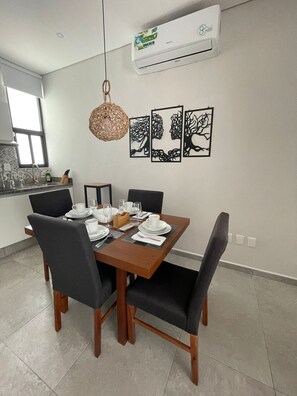 Enjoy meals in this dining area with a rectangular table and four chairs, illuminated by a pendant light fixture.