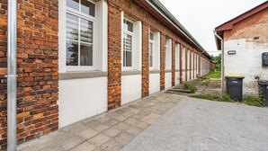 A long row of brick buildings with white window frames and a paved walkway.