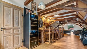 Un interior rústico con vigas de madera a la vista, un refrigerador para vino y un comedor.