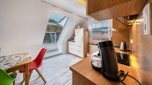 A compact kitchen with a microwave, toaster, kettle, and a coffee machine on a wooden countertop. - Apartment 'Burgblick' with Mountain View, Shared Garden and Wi-Fi (Hausach)