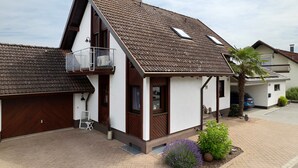 A modern house with a sloped roof, a garage, and a small balcony. - Holiday Home 'Ferienhaus Am Rhein' with Private Terrace, Balcony and Wi-Fi (Rheinau)