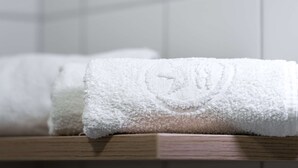 A white towel with a logo on a wooden surface.