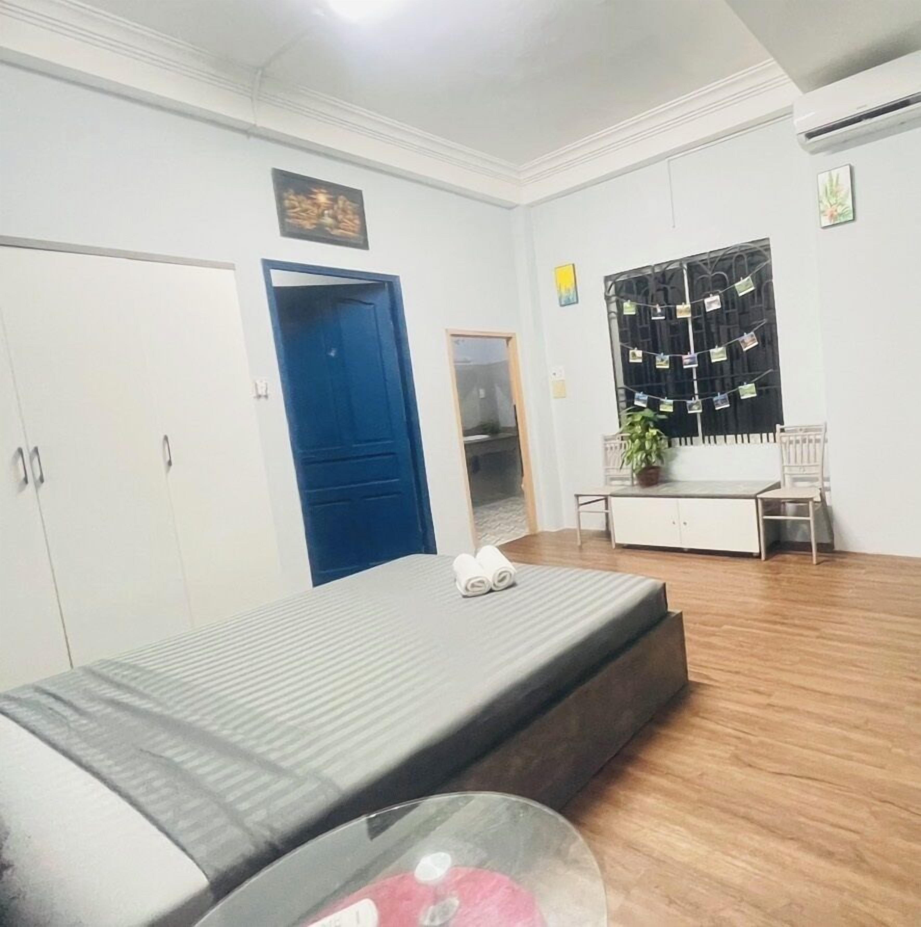 Una habitación con cama, escritorio, silla, armario y aire acondicionado.
