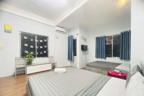 A bedroom with a bed, a bench, a TV, and a window with curtains. - Lyly Hotel - Pham Ngu Lao (Ho Chi Minh City)