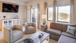 A living room with a sofa, armchairs, a coffee table, a TV, a cabinet, and a window with curtains. - 2 Mi to Ski Resort! Sugar Mtn Condo w/ Indoor Pool (Sugar Mountain)