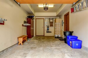 A hallway with a bench, a door, and a trash bin. - Montebello 4864 - Private Hot Tub, Air Conditioning, Short Walk to the Village (Whistler)