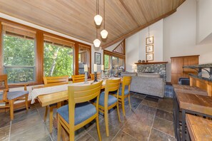 A dining area with wooden furniture and a stone fireplace.