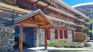 A multi-story building with balconies, stone walls, and a wooden entrance. - Bright studio for 4 people with magnificent view (Les Deux Alpes)